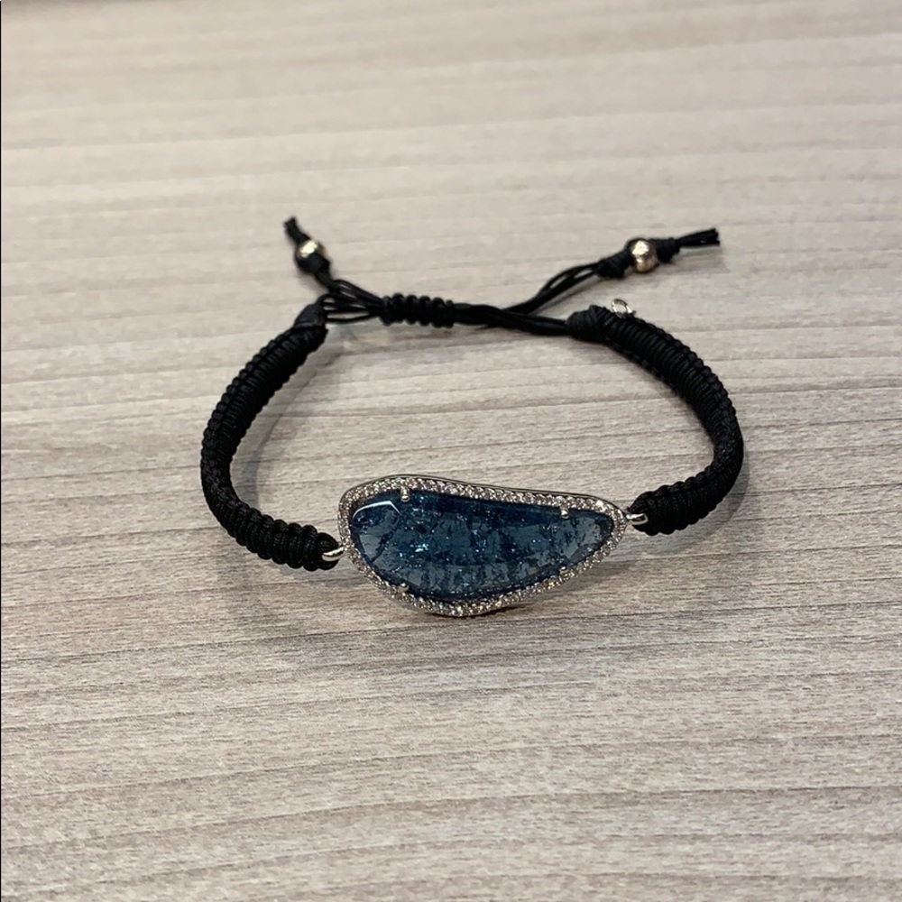 Braided cord bracelet with large blue stone .